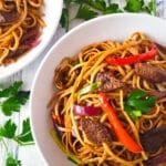 Tallarin Saltado served in two white bowls.