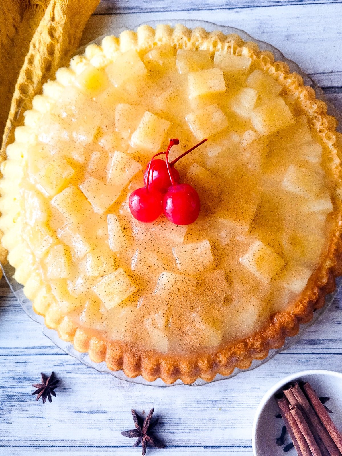 Temblecocho served on a clear serving platter topped with a pineapple glaze and cherries.