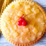 Temblecocho served on a clear serving platter topped with a pineapple glaze and cherries.