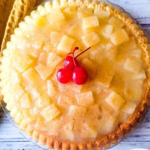 Temblecocho served on a clear serving platter topped with a pineapple glaze and cherries.