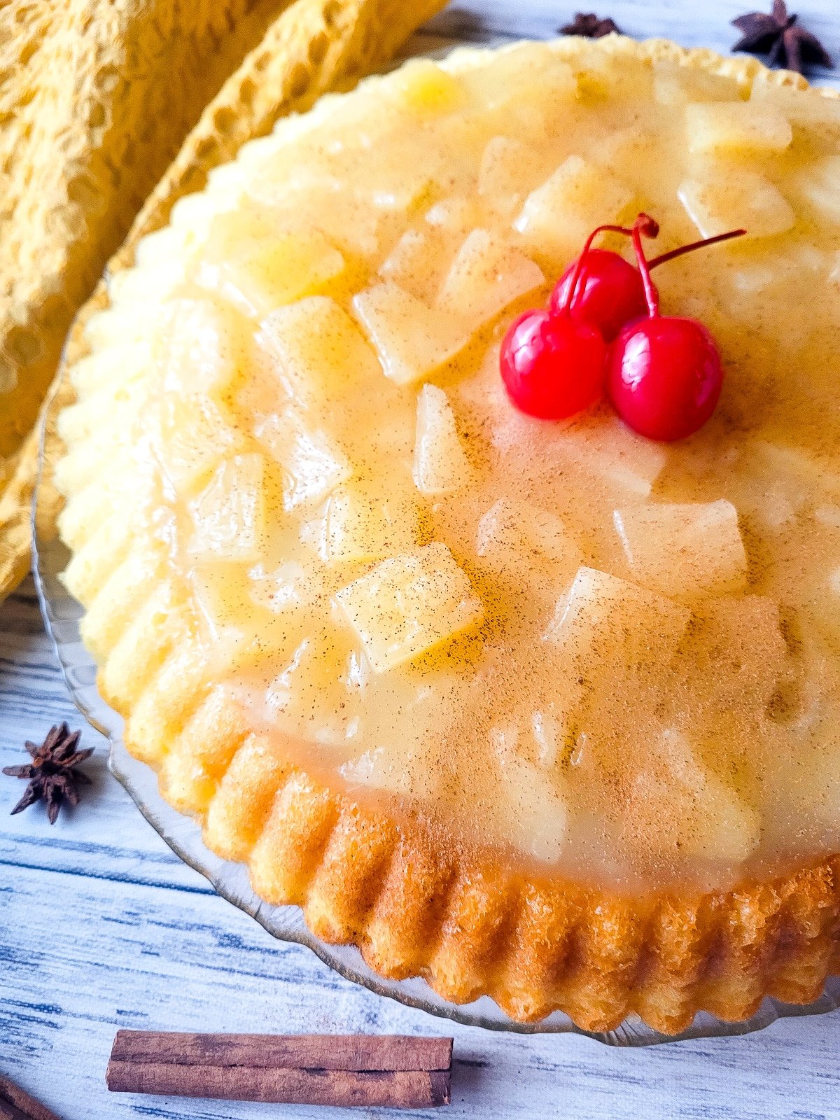 Temblecocho served on a clear serving platter topped with a pineapple glaze and cherries.